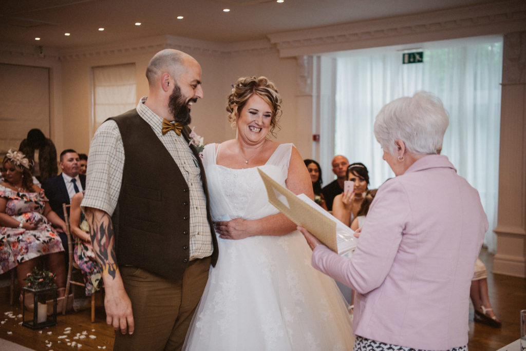 Bride and groom laugh at a joke told by the celebrant in the langtree suite
