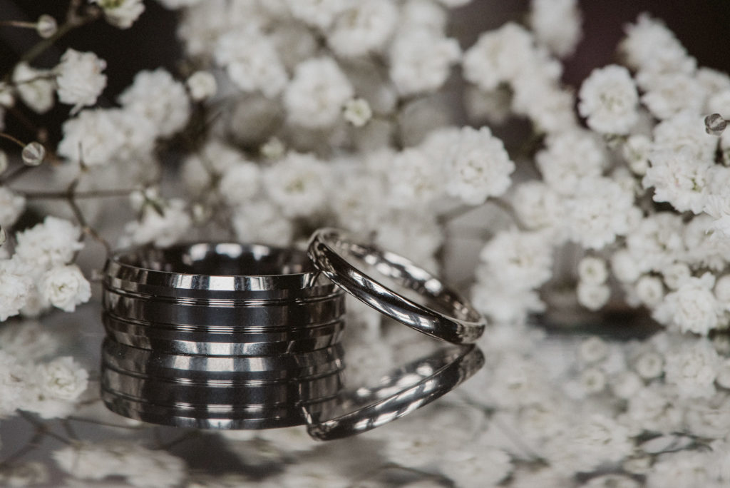 Wedding rings sitting on table with gypsophila in the background
