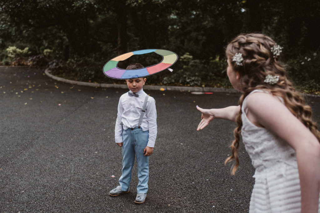 A young wedding guest throws a frisbee at her young brother during a wedding