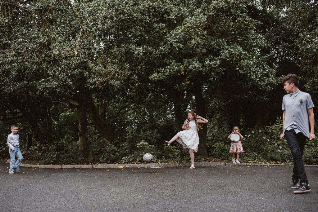 Children play with a football on the grounds of Ashfield House during a wedding