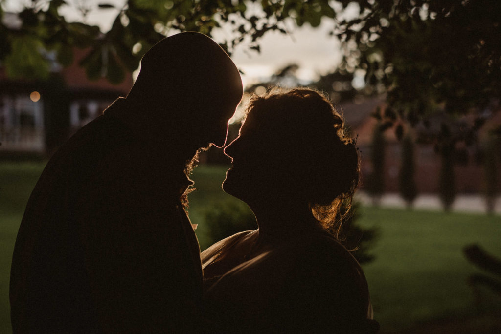 A silhouette of a bride and groom with the sun directly behind them at golden hour