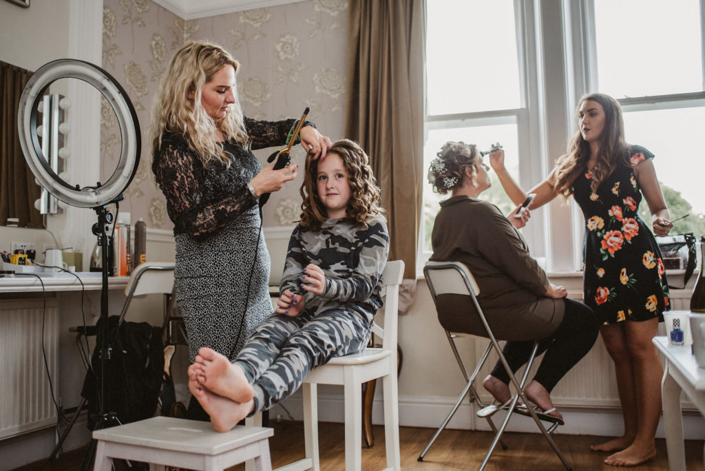 Multiple people having their hair done in preparation for a wedding