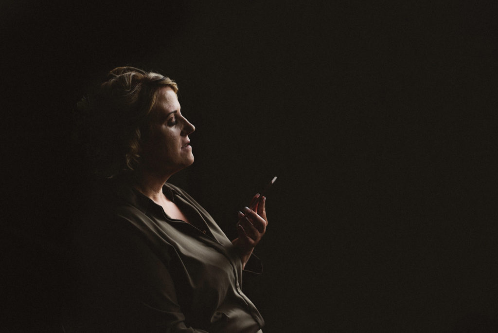 Bride talking on mobile phone with black background