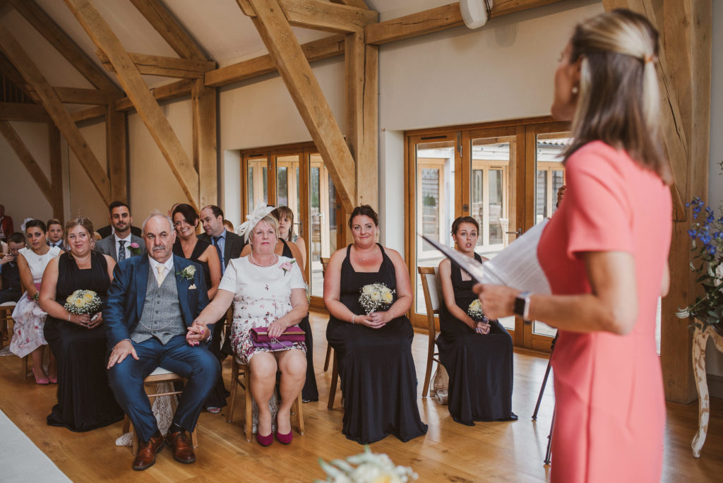 mother of the bride holds hands with the father of the bride during the wedding ceremony in the Ceremony Barn