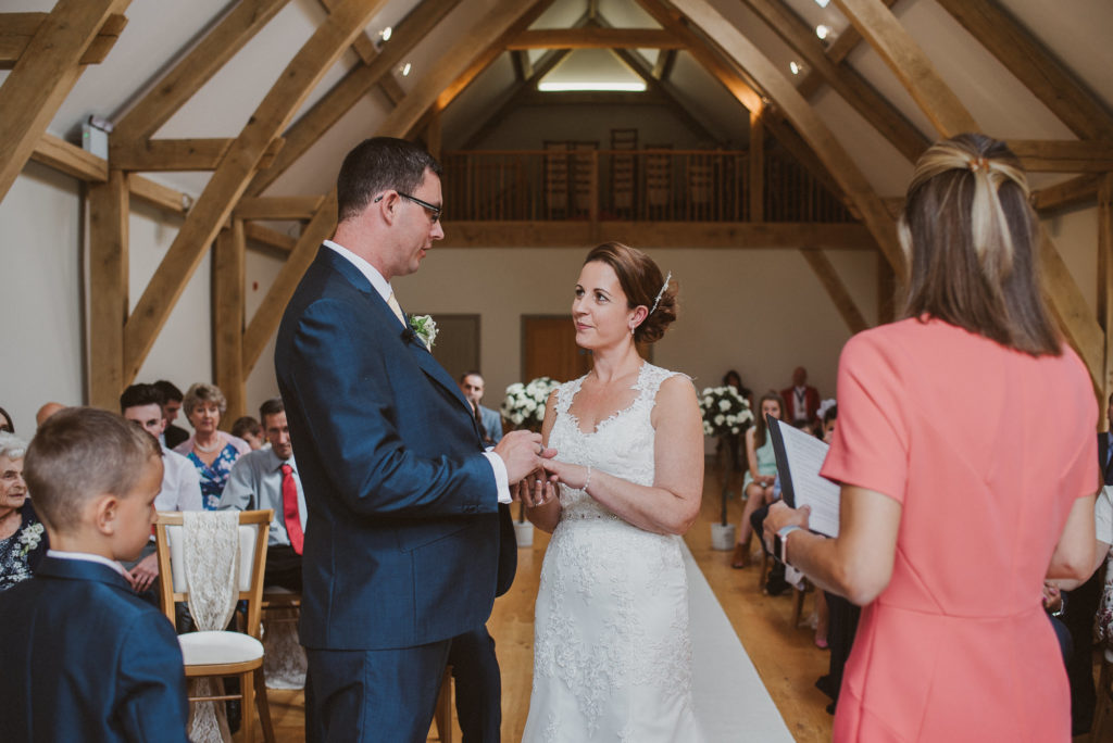 bride and groom look at each other during their barn wedding ceremony at Easton Grange