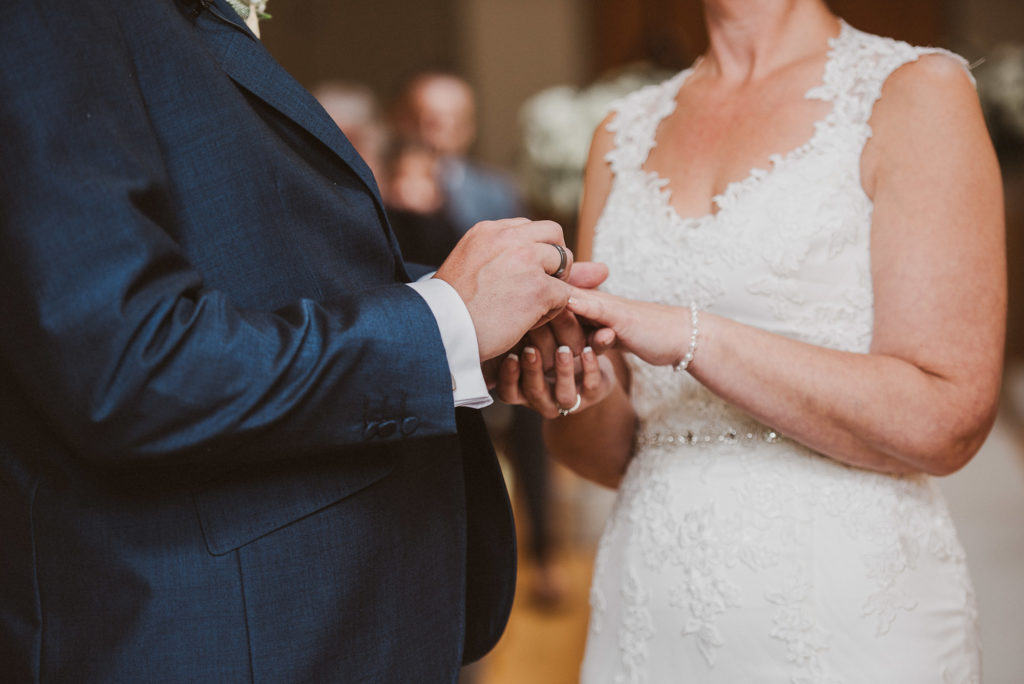 Surrey bride and groom exchange rings during their wedding ceremony