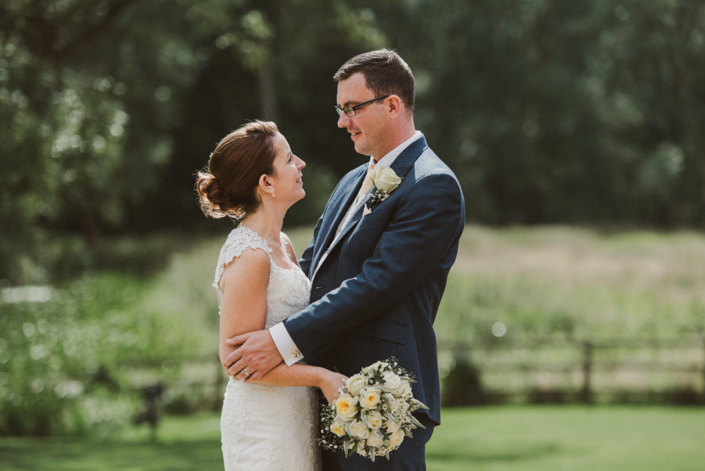 bride and groom look lovingly at each other in the field at their farm wedding