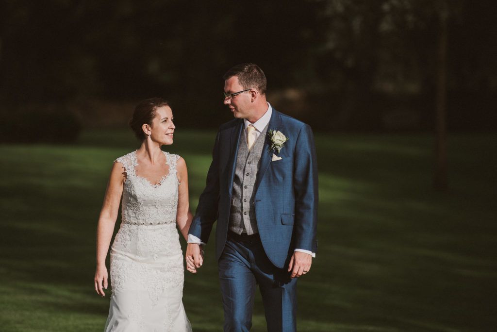 bride and groom walk along looking at each other