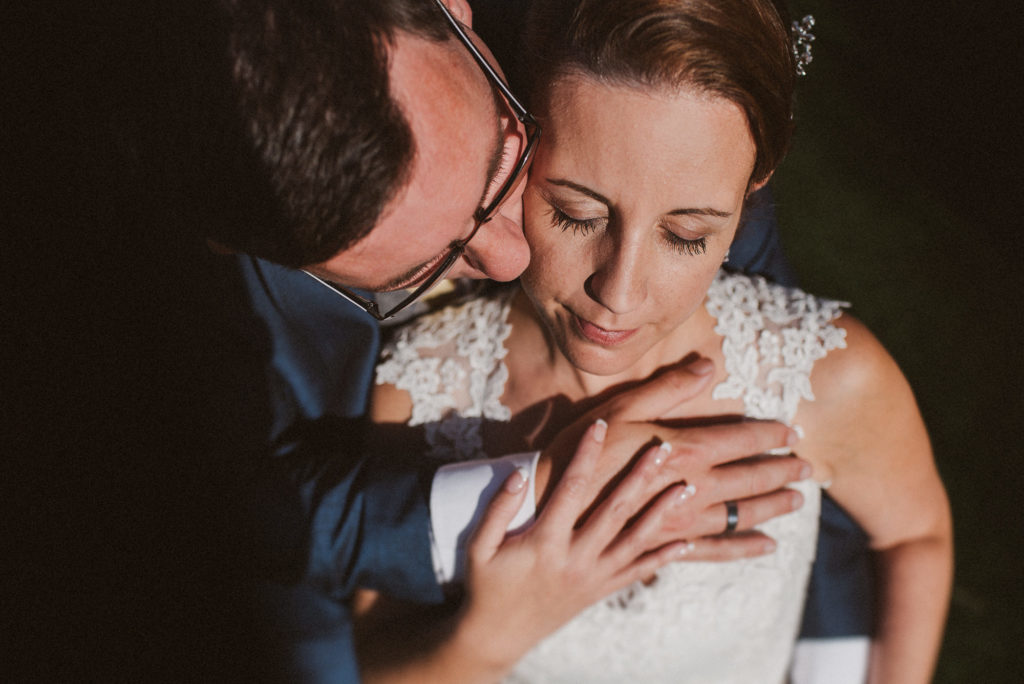 Surrey groom embraces his bride romantically