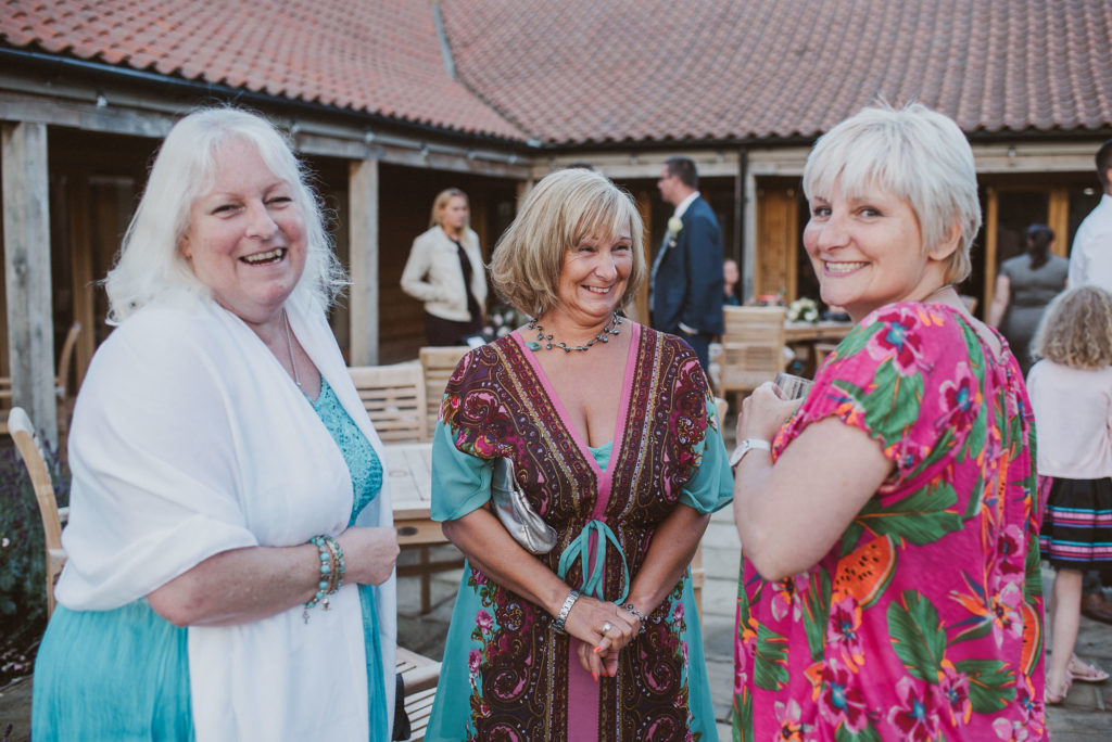 wedding guests laugh at a barn wedding