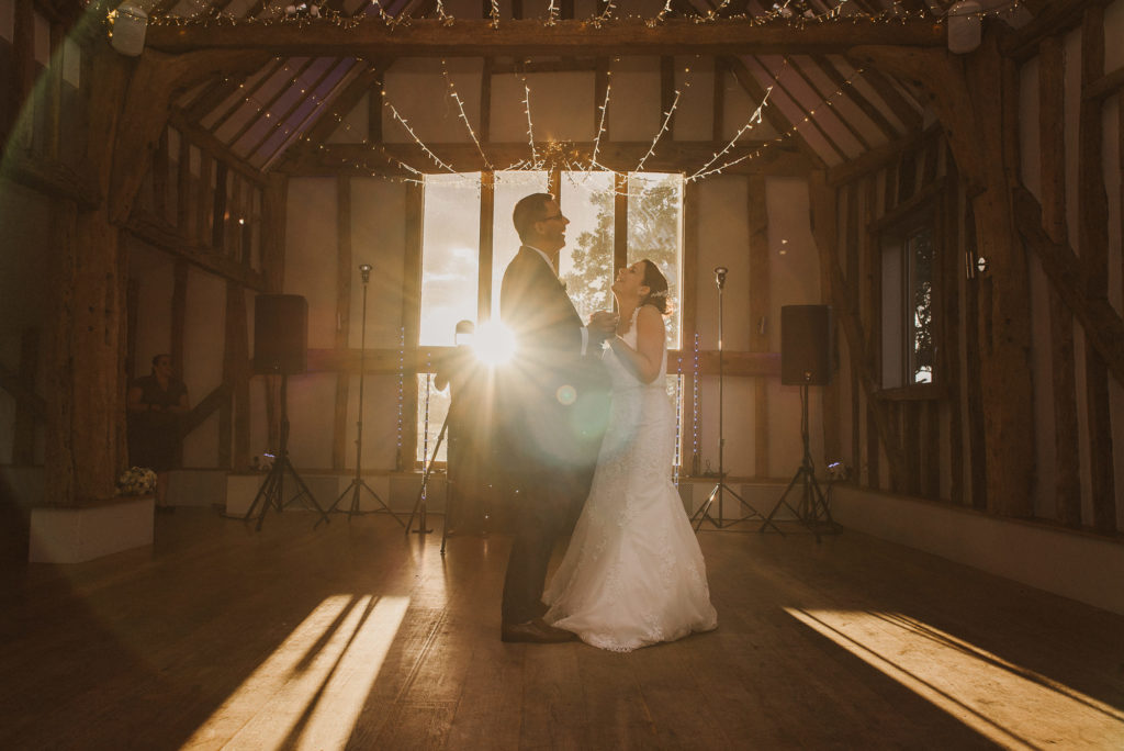 bride and groom dance during their first dance in a barn at Easton Grange