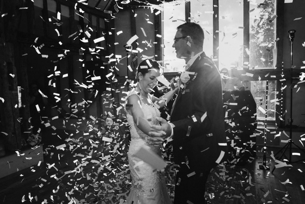 couple dance surrounded by a lot of confetti at their barn wedding