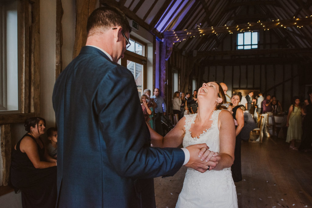 bride having a good time and laughing during her first dance