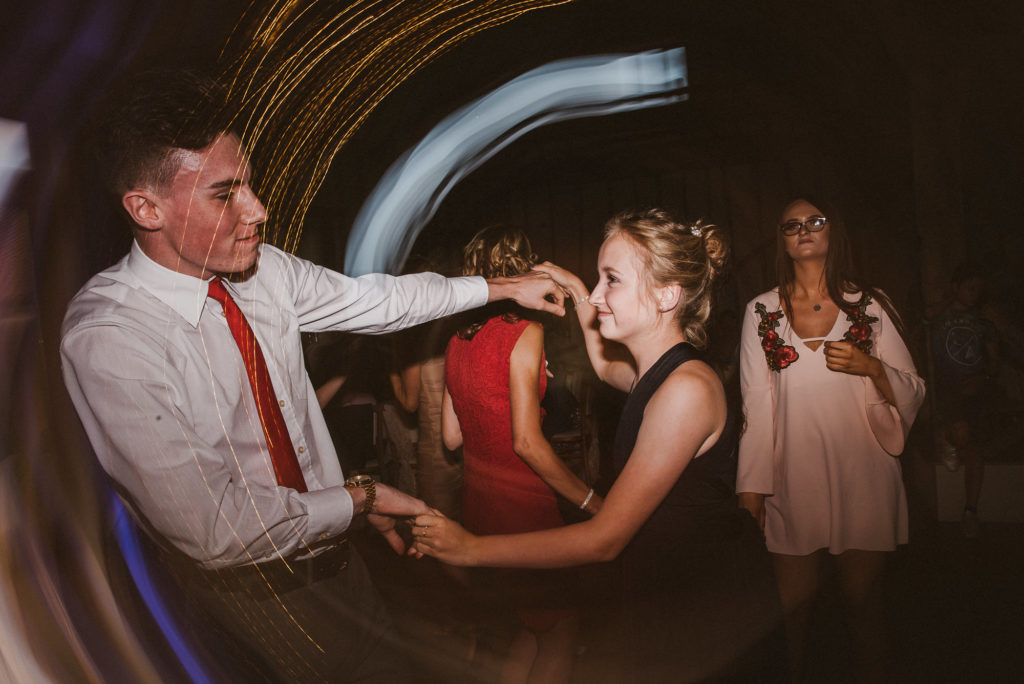 wedding guests dance happily at a barn wedding