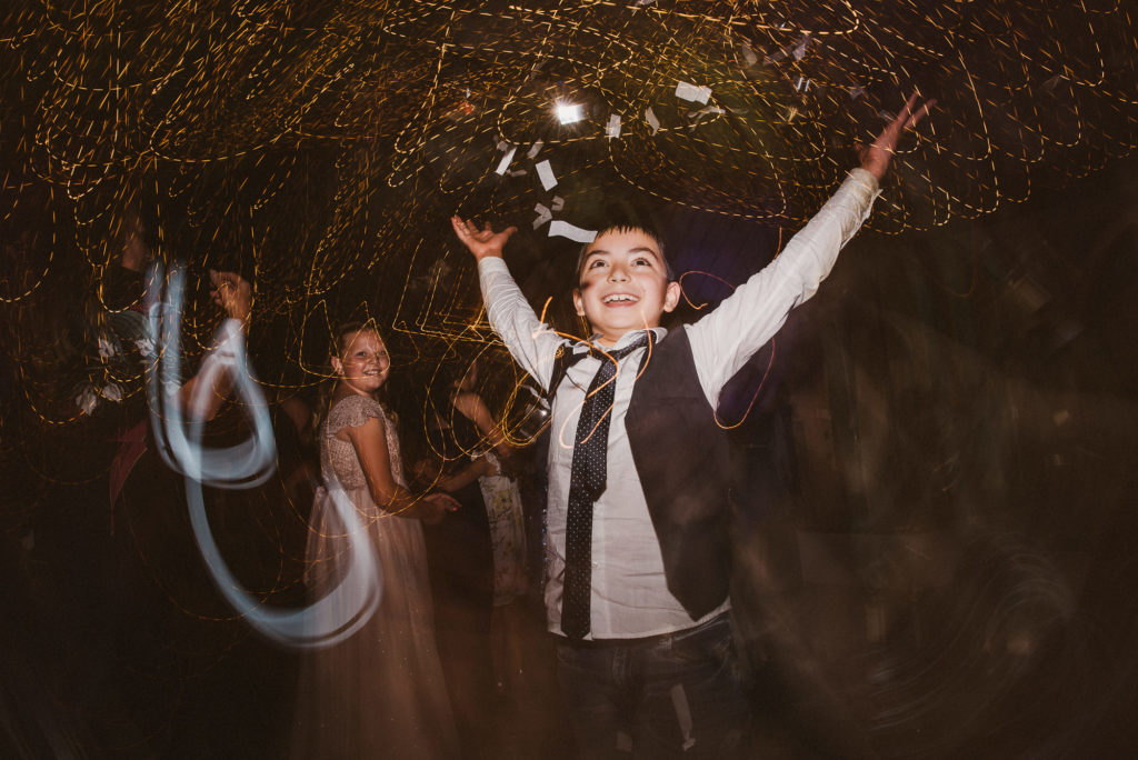 wedding guest throws confetti into the air at a wedding reception