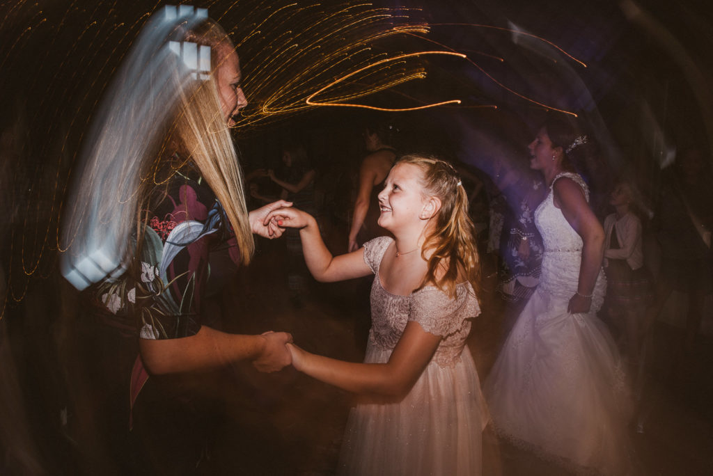 guests dance during a wedding reception in a barn
