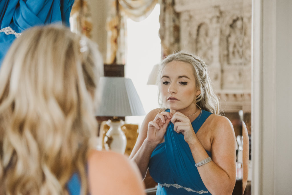 bridesmaid puts necklace on in the Lady Astor Suite at Cliveden