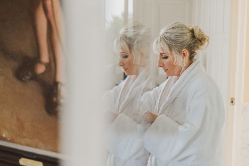 bride handles garter in front of mirror in the Lady Astor Suite