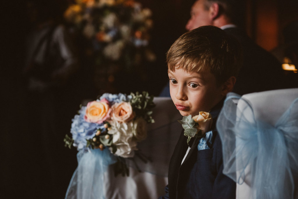 page boy makes a silly face during a Berkshire wedding ceremony