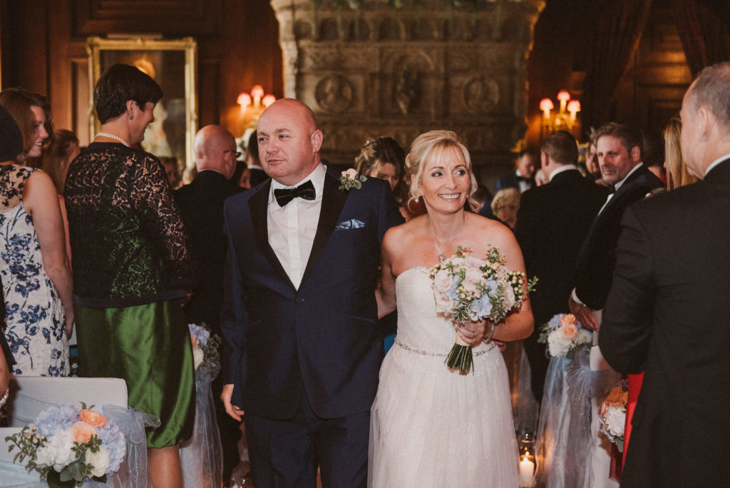 bride and groom walk happily up the aisle together after getting married at Cliveden House