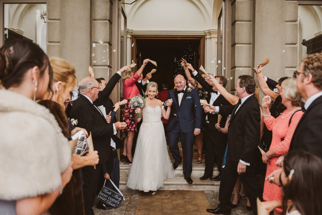 London bride and groom walk through confetti tunnel at Cliveden House