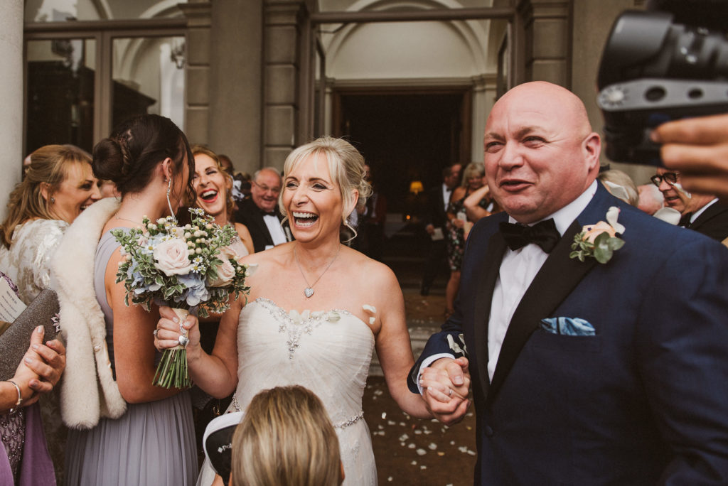 bride laughs after getting confetti thrown at her