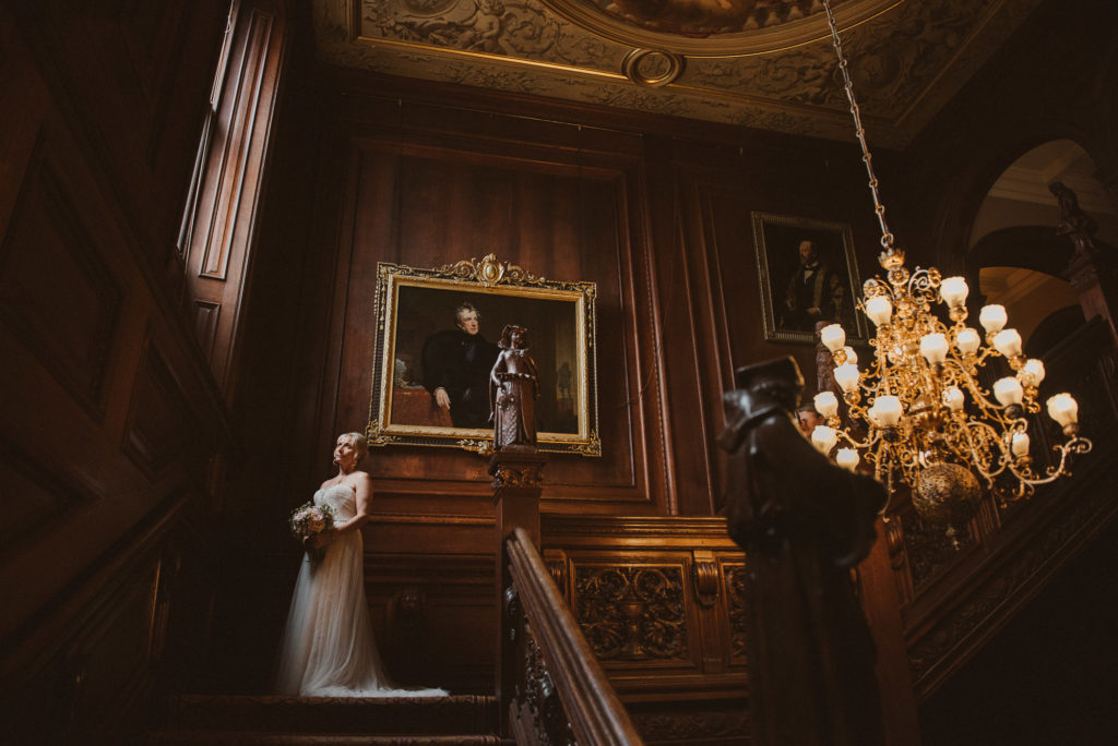 bride looks out of the window on the main staircase at Cliveden House