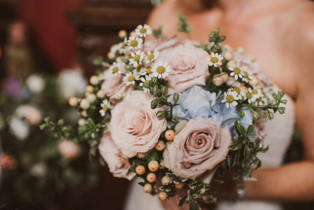 bride holds bouquet with pink roses