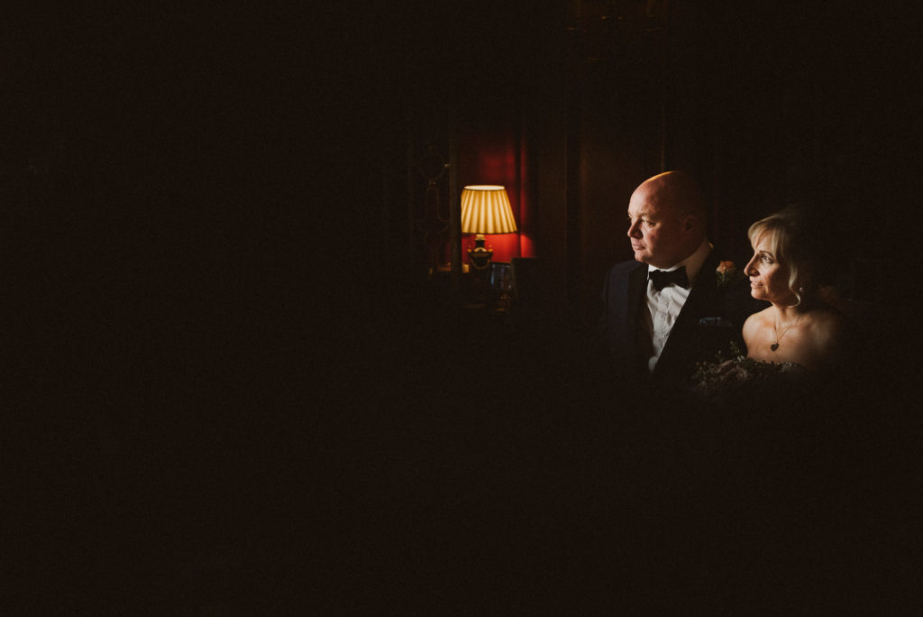 bride and groom look towards a lamp in the darkness