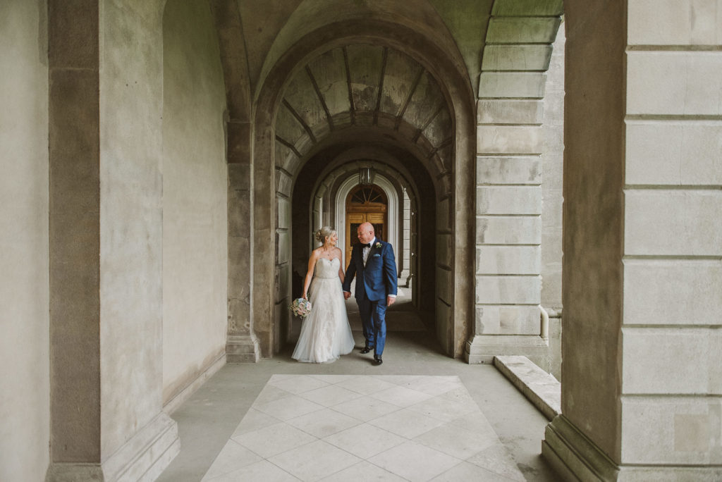 bride and groom walk along and look into each others' eyes at Cliveden