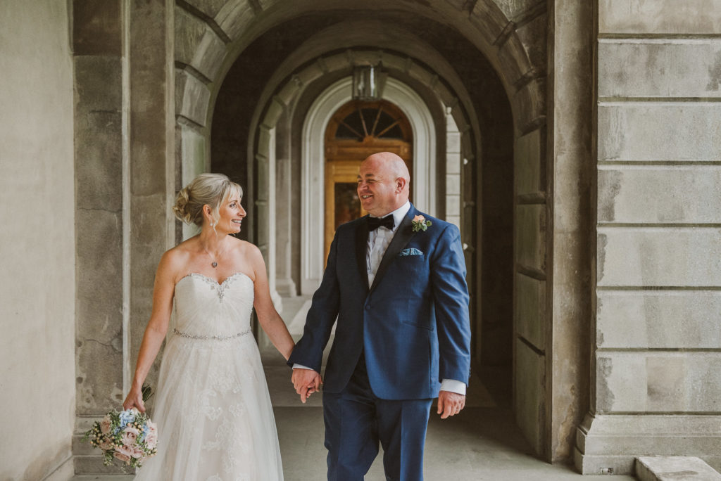 bride and groom laugh as they walk along near London