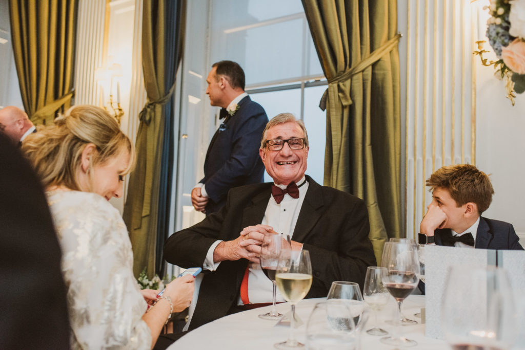 a wedding guest smiles during a wedding breakfast in the French Dining Room