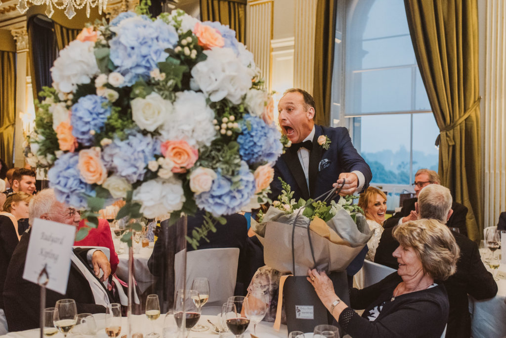 a wedding guest looks very surprised during a wedding breakfast near London