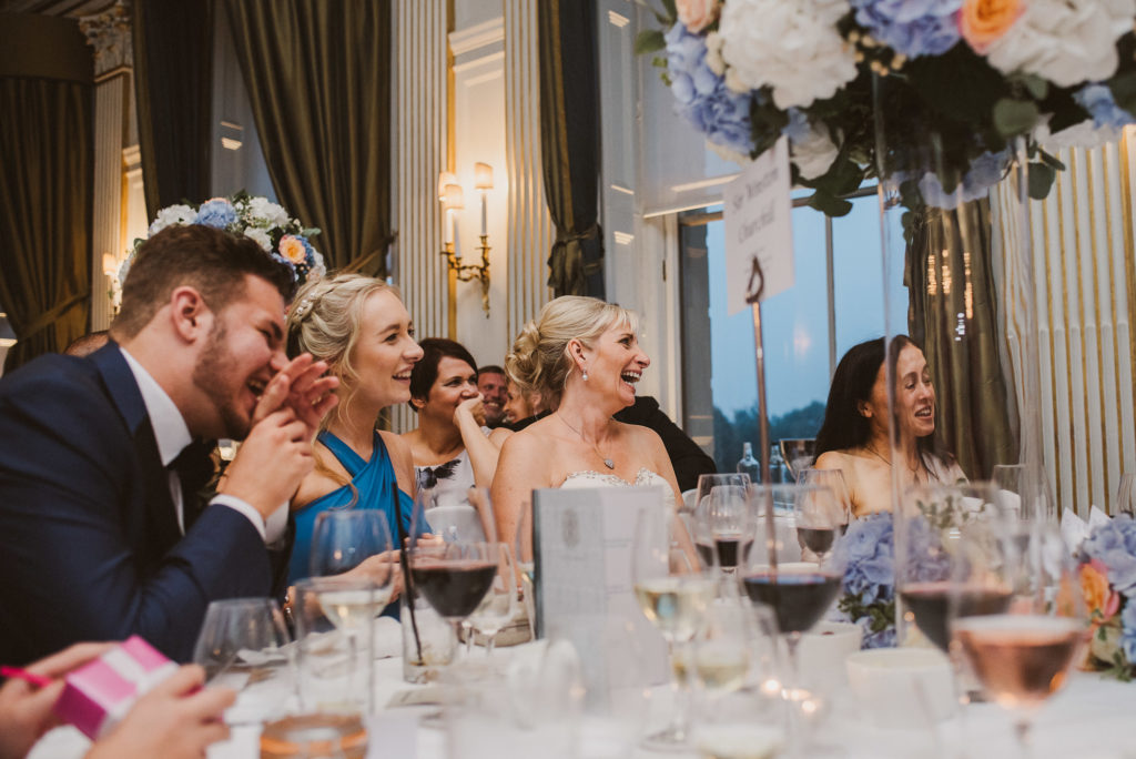 bride laughs at the groom's speech at their wedding breakfast at Cliveden