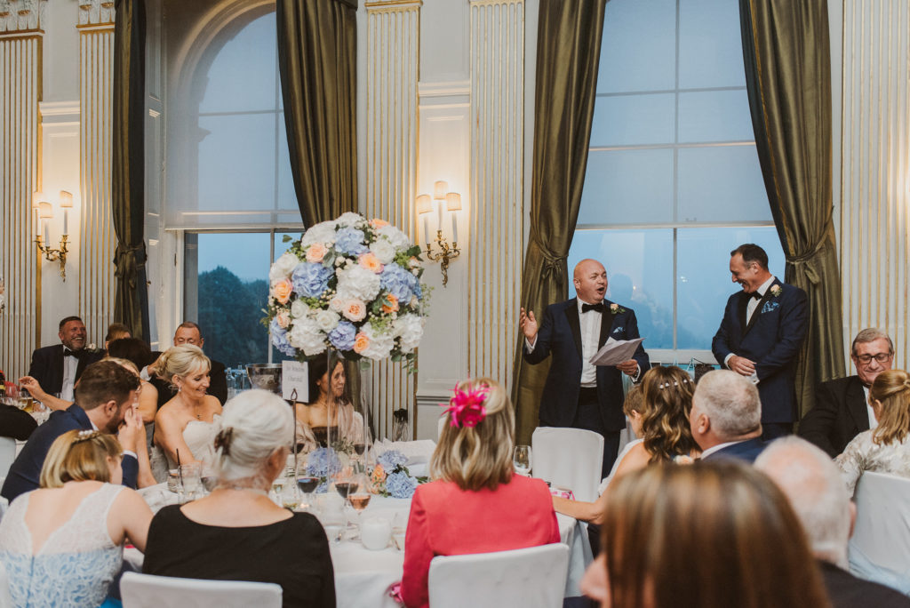 groom speaks to his best man during speeches
