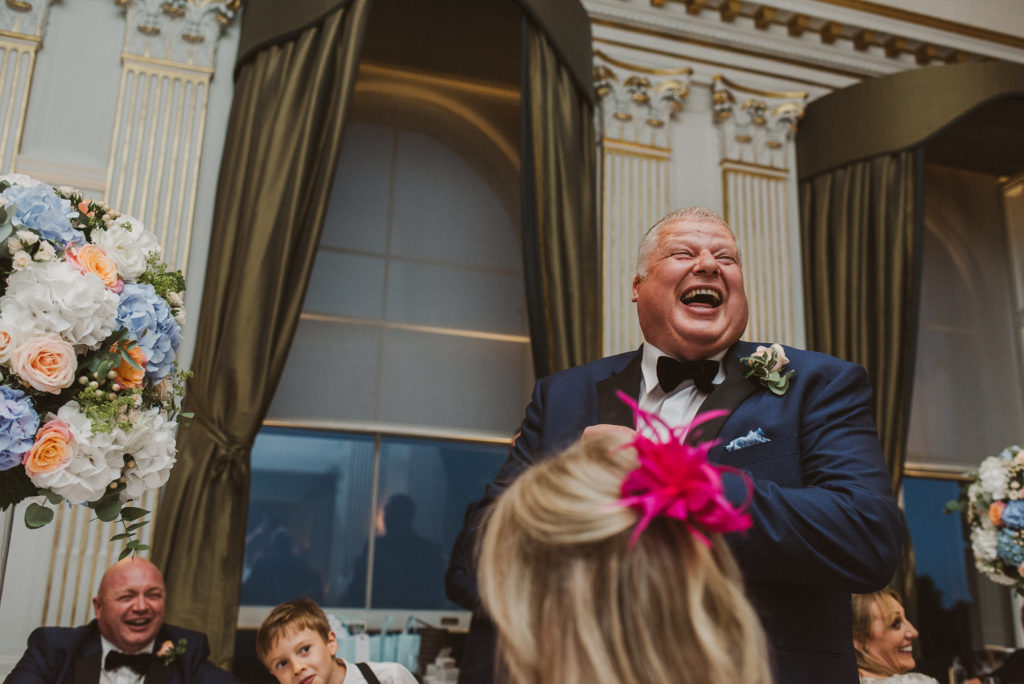 a groomsman laughs joyfully during wedding breakfast speeches