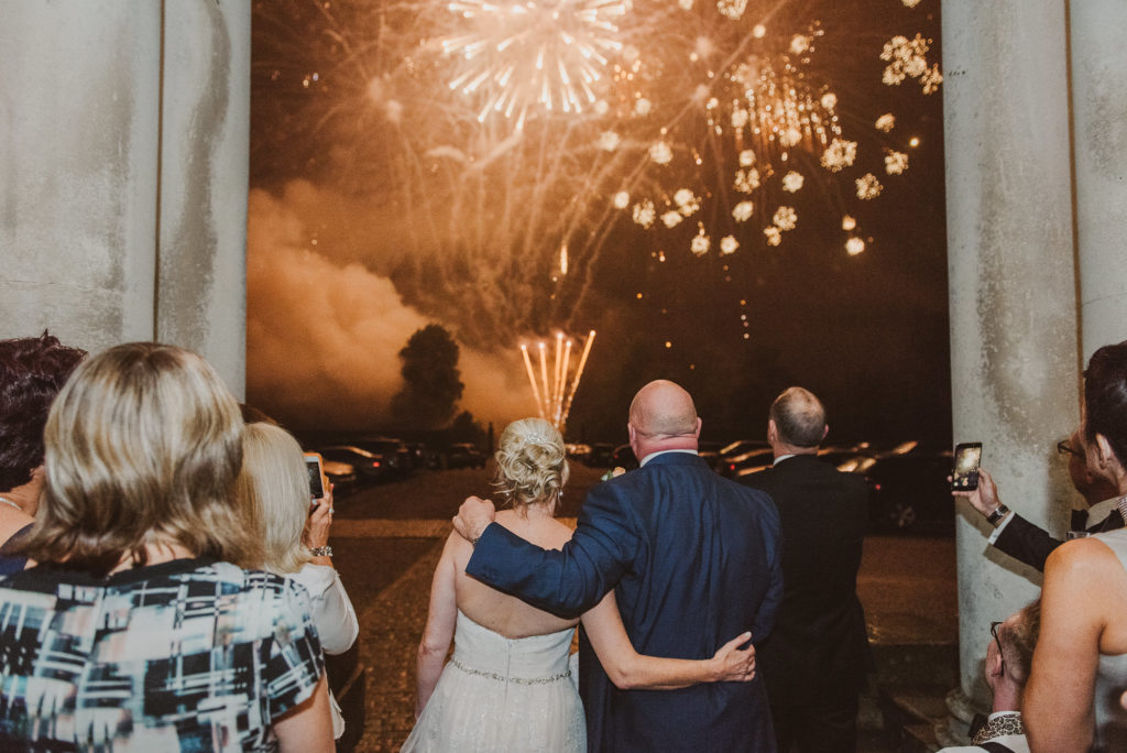 bride groom and wedding guests watch a fireworks display outside Cliveden House