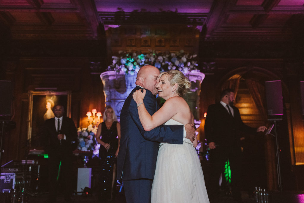 bride and groom embrace during their first dance in the Great Hall at Cliveden