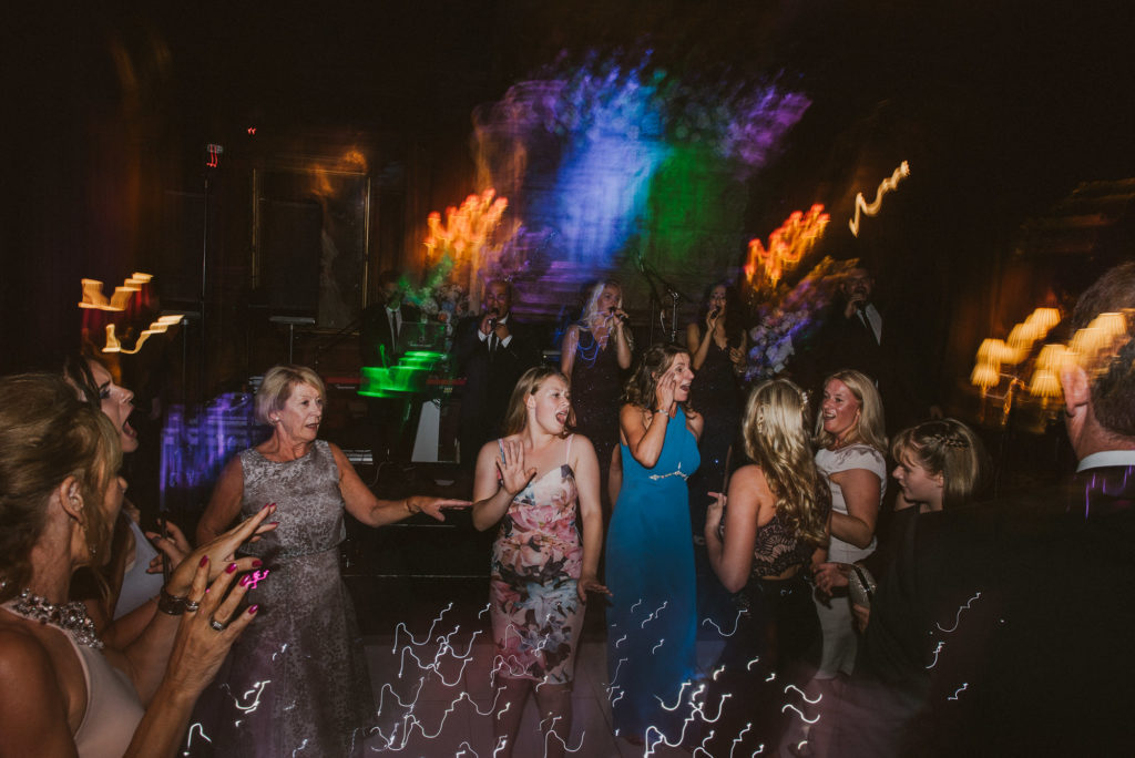 wedding guests let their hair down and dance in the Great Hall during a wedding reception