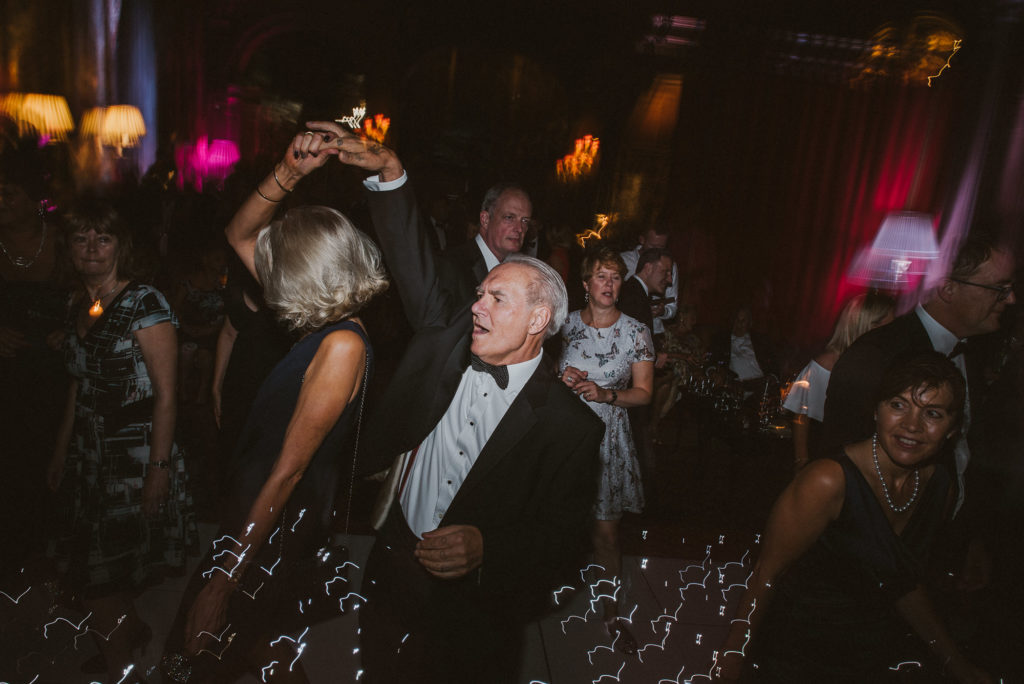 a man in a bow tie spins a woman around in a black dress