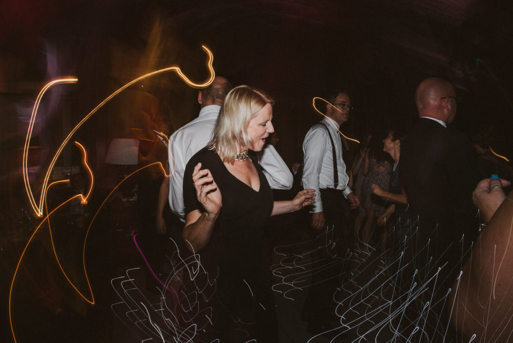 a wedding guest dances with light trails surrounding her in the Great Hall
