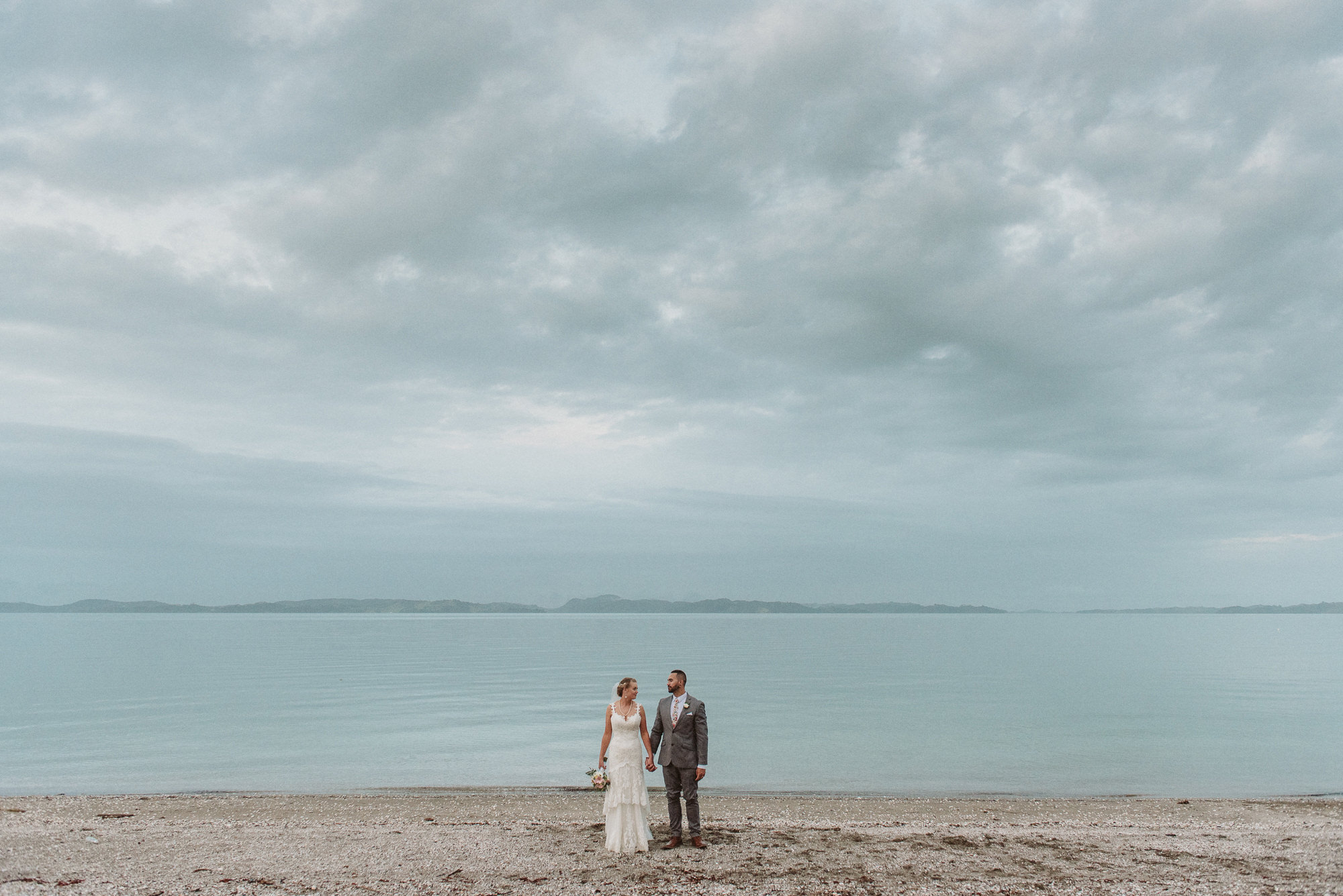 A couple stand in front of the sea at Maraetai Beach